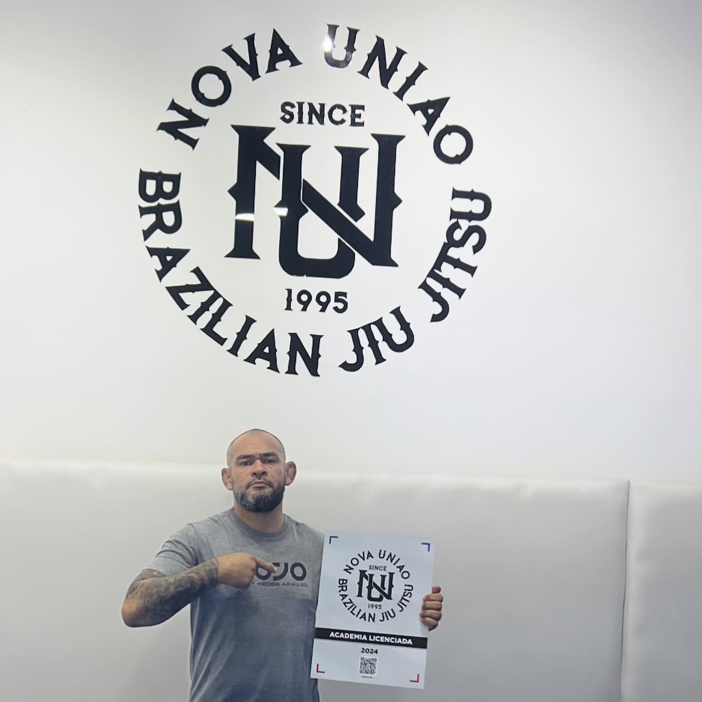 Mestre Heder segurando o certificado de academia licenciada da Nova União.